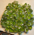 A collection of rough peridot stones displayed on a flat surface.
